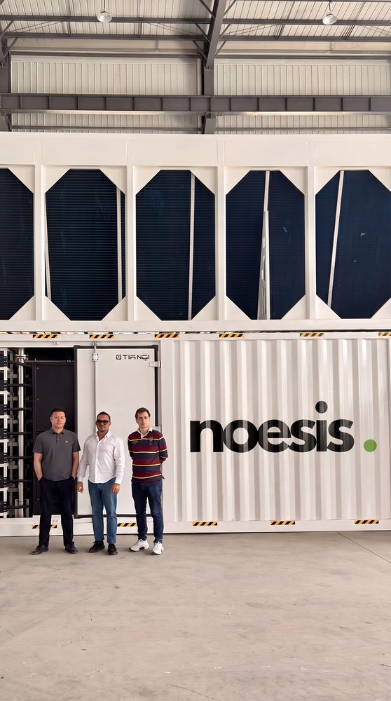 Team in front of a NOESIS-branded containerised data centre